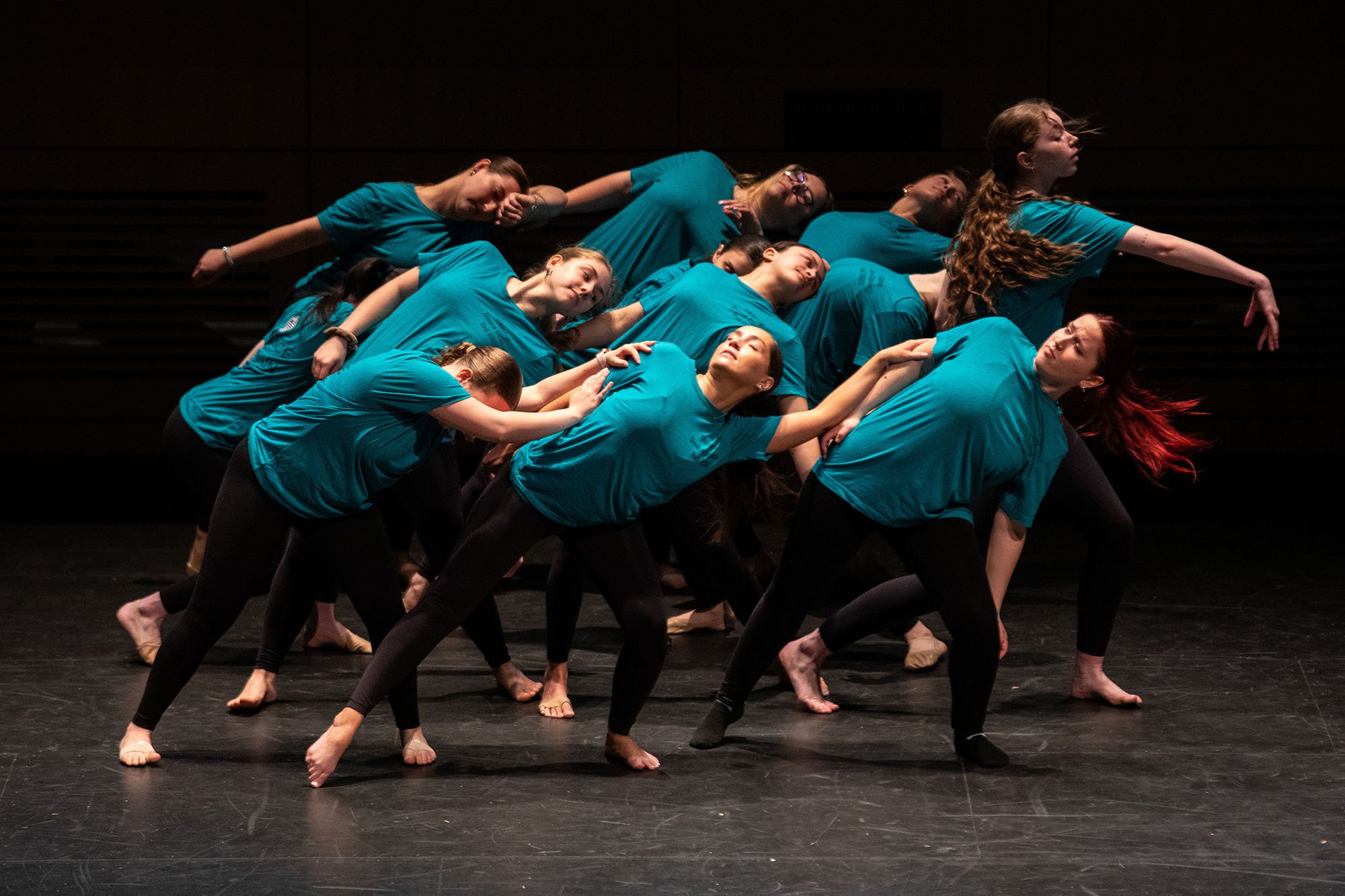Students in blue shirts and black leggins perform artistic dance on stage at UAlbany Showcase Day 2024.