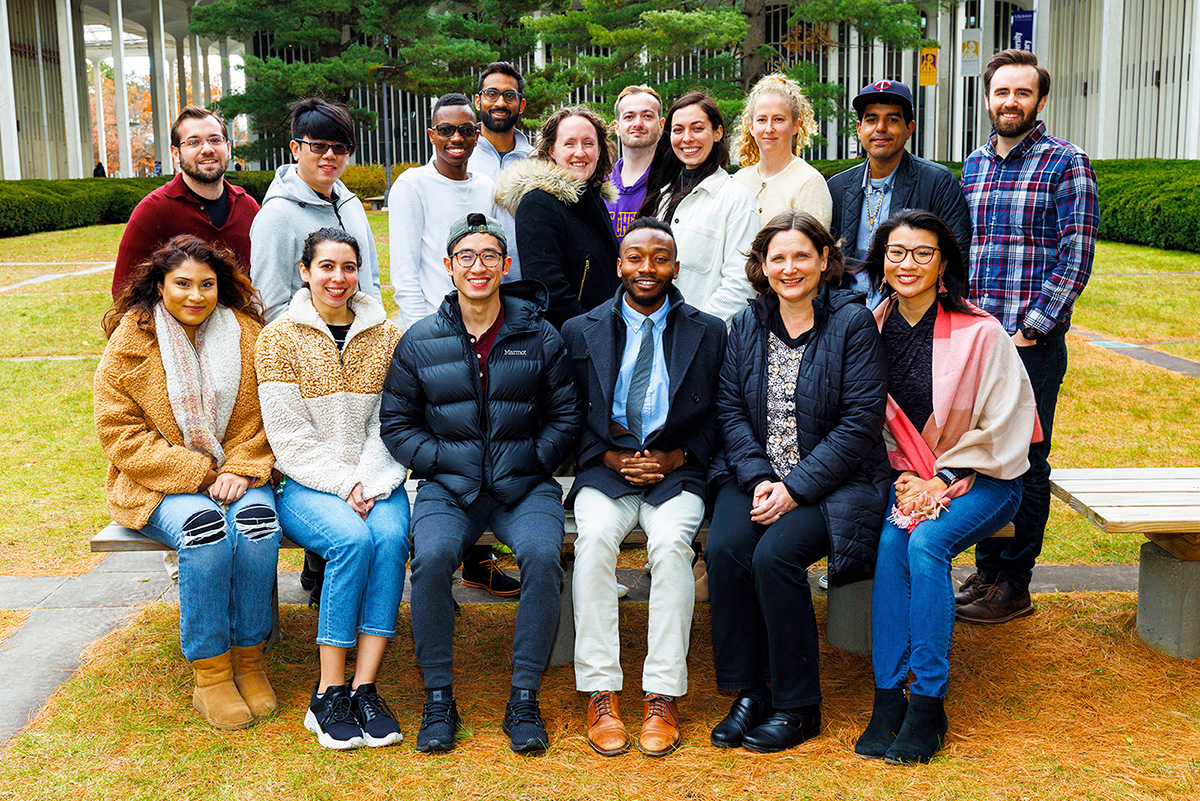 A diverse group of UAlbany Industrial and Organizational Psychology students and faculty in a campus courtyard