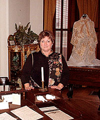 Kate Winter at Holley's writing desk, her writing jacket in the background right, at the Jefferson County Historical Society.