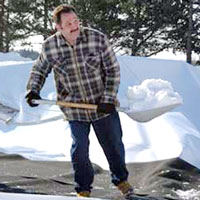 Tom Curtain shovels snow from the deflated Bubble.