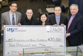 five people stand holding an enormous ceremonial check for $30,000 to the School of Business from the CPA firm UHY
