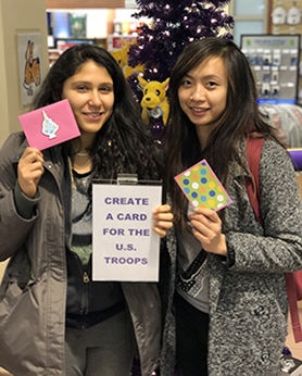 two students make cards for the troops 