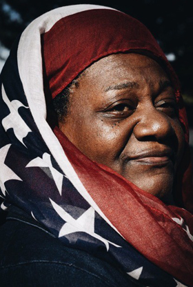 Woman wearing American flag head covering. 
