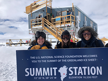 UAlbany students take photo behind signage at NSF's Summit Station in Greenland.