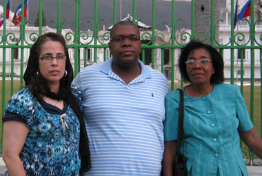 Maritza Martinez, Patrick Romain, and Monette Fils in front of the damaged Presidential Palace in Haiti. 