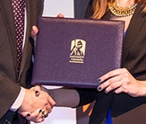 photo of an award and two people shaking hands