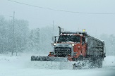 Photo of a plow clearning snow off highway.