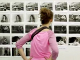 A UAlbany student inspects the photography exhibition of a studio arts major.