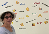 Professor Laurie Feldman in front of a wall of emojis.