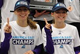 2 victorious America East champion UAlbany women harriers hold up their #1 index fingers.