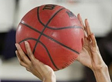 A basketball, held by a UAlbany women's basketball player