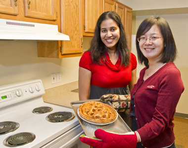 Two international students with an apple pie for Thanksgiving.