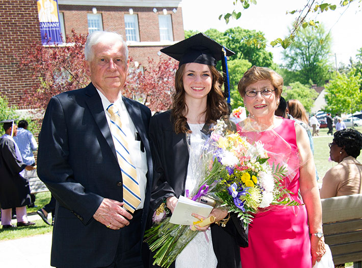 Parents celebrate with their daughter at UAlbany commencement ceremony