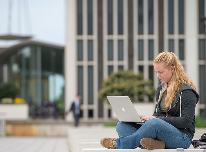 Student works on her computer outside on UAlbany's uptown campus