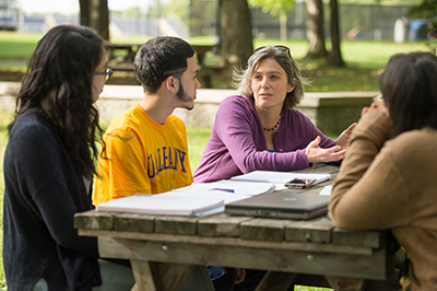 Students working with a professor on campus