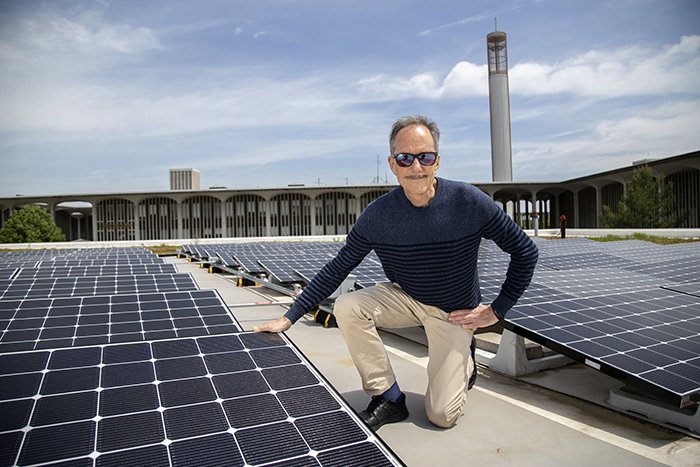 ASRC senior research associate Richard Perez observes an array of 90 LG 350-watt solar panels installed on the University at Albany Campus Center West addition roof. (Photo by Patrick Dodson)