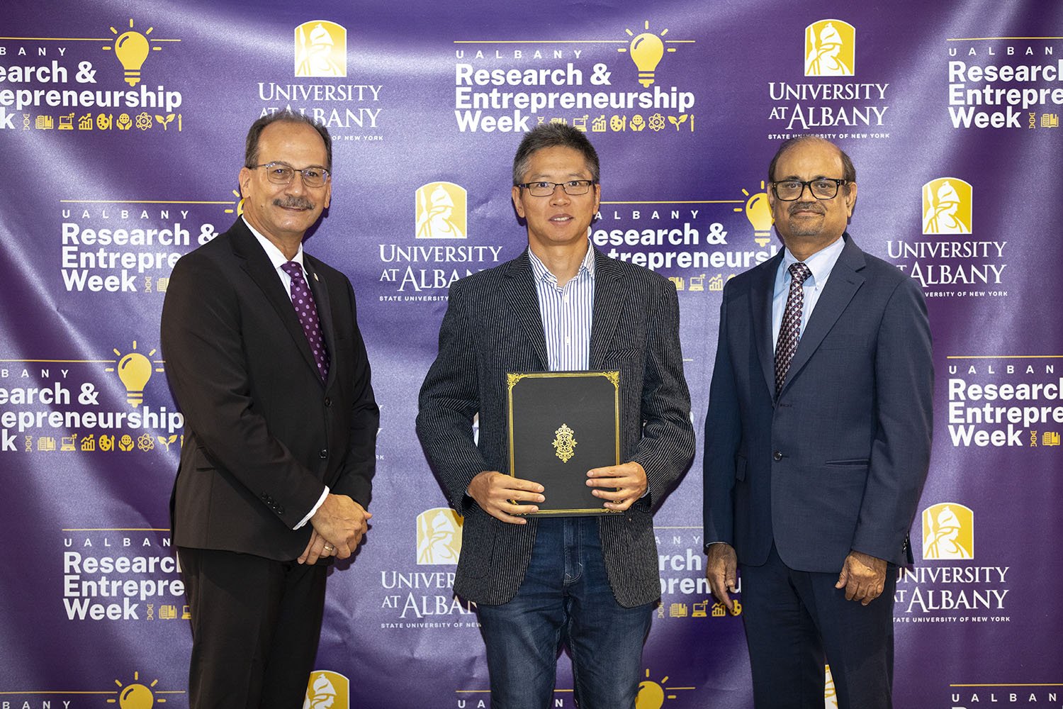 Jia Sheng, The RNA Institute, with UAlbany President Havidán Rodríguez and Vice President for Research and Economic Development Thenkurussi “Kesh” Kesavadas.