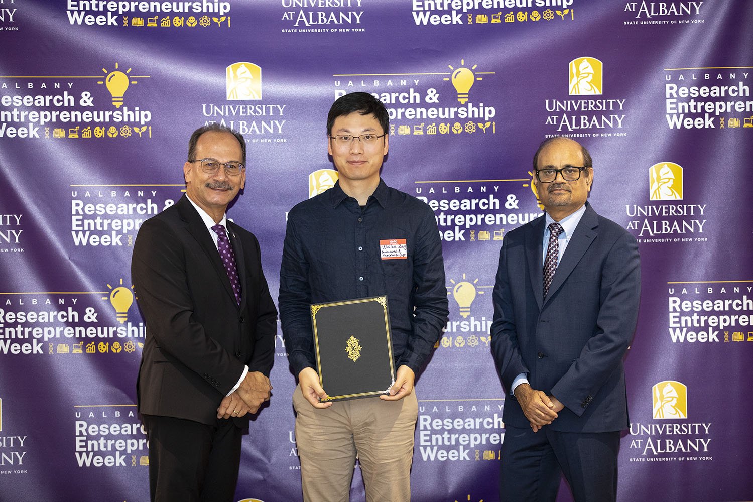 Weilan Zhang, CNSE, with UAlbany President Havidán Rodríguez and Vice President for Research and Economic Development Thenkurussi “Kesh” Kesavadas.