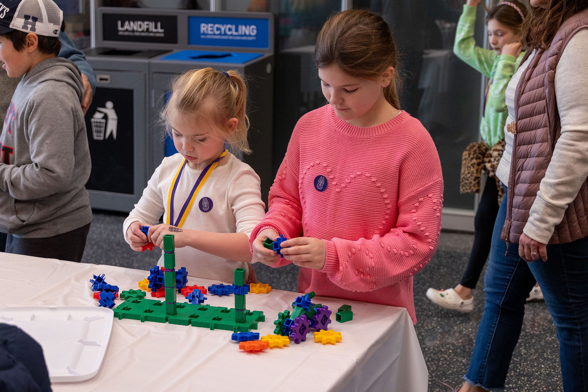Two young girls conduct a tabletop experiment at UAlbany's STEM & Nanotechnology Family Day at ETEC.