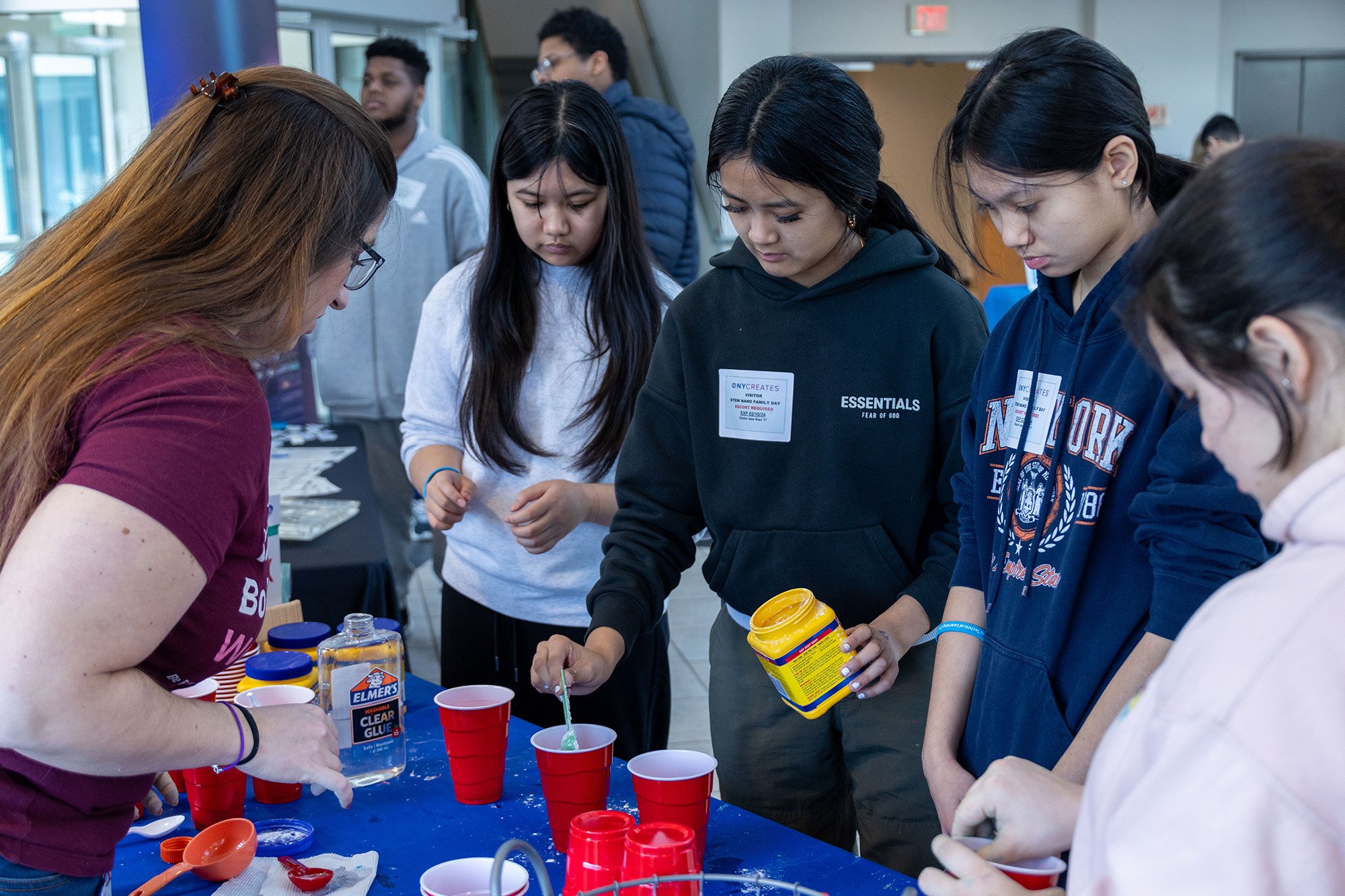 A group of young women take part in a table-top experiment at UAlbany's STEM & Nanotechnology Family Day at NY CREATES' Albany NanoTech Complex.