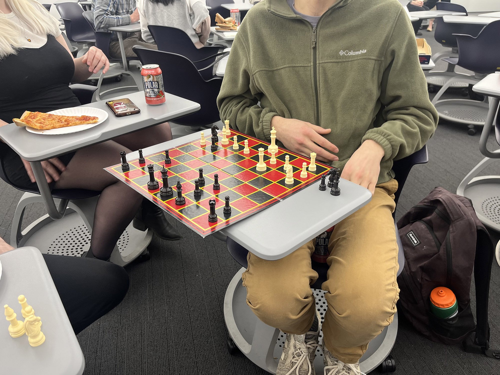 A student sits with a chess board at Pi Day 2024 at UAlbany.