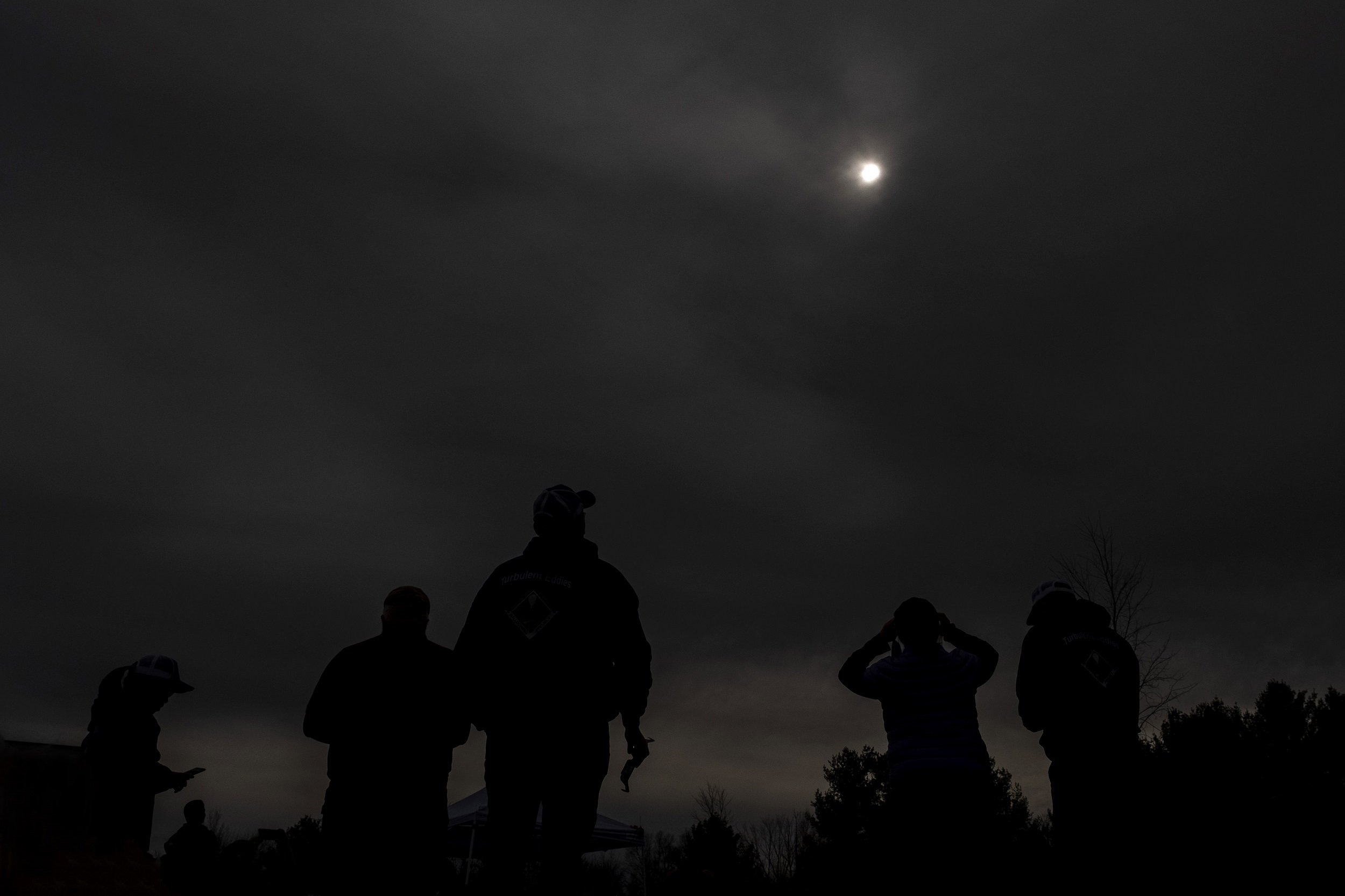 UAlbany students view what's remaining of the sun in near total darkness at Fort Drum.