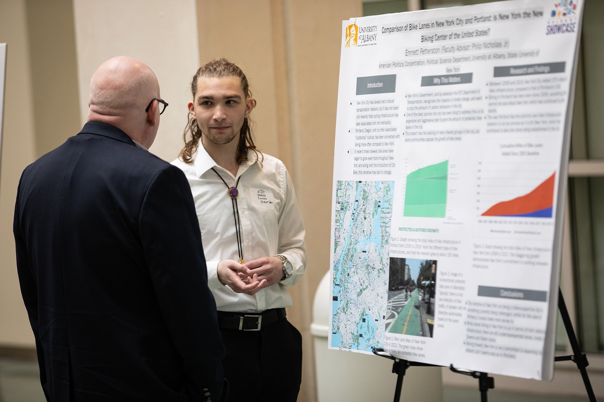 A student discusses his poster on bike paths during Showcase Day 2024.