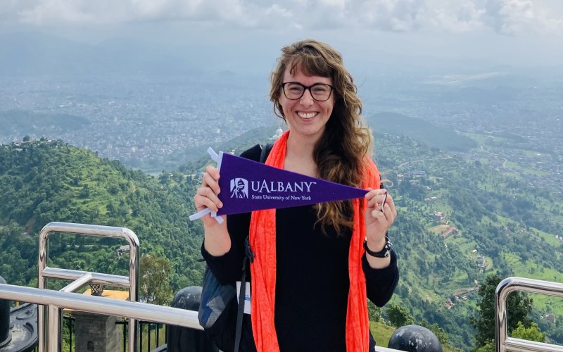 Chloe Glenn posing with a UAlbany pendant on one of her recruitment trips.