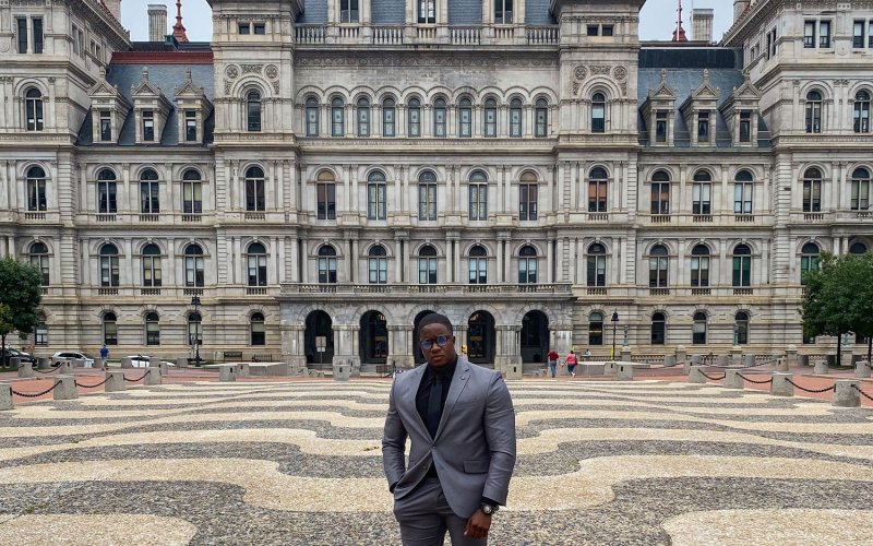 Jeremy Baker poses in front of the New York State Capitol building in Albany.