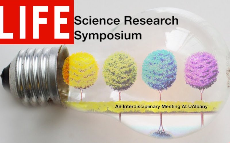 A lightbulb with multicolor trees growing inside of it, with the words "Life Science Research Symposium," above and the  words "An Interdisciplinary Meeting At UAlbany beneath the trees. The word "Life" is in a red box, design d to look like a Life magazine cover.