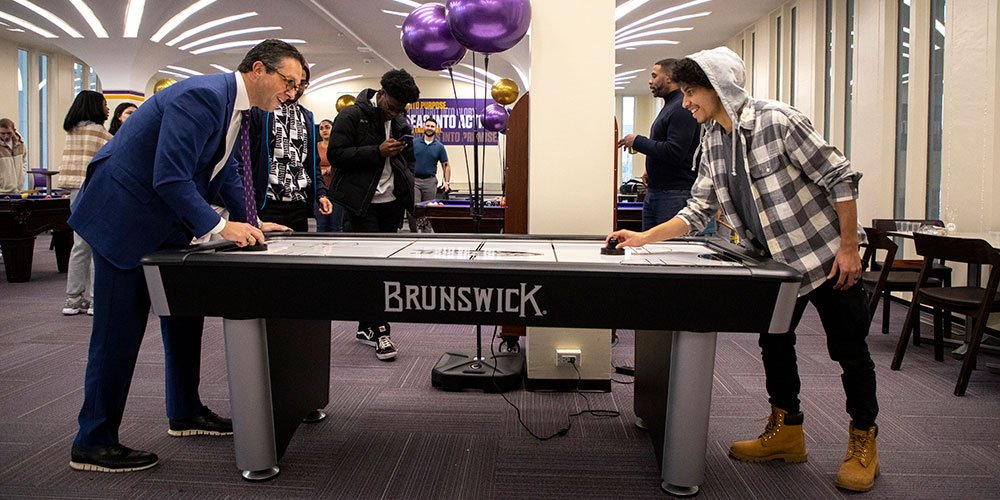 Students playing air hockey in the Campus Center Game Room
