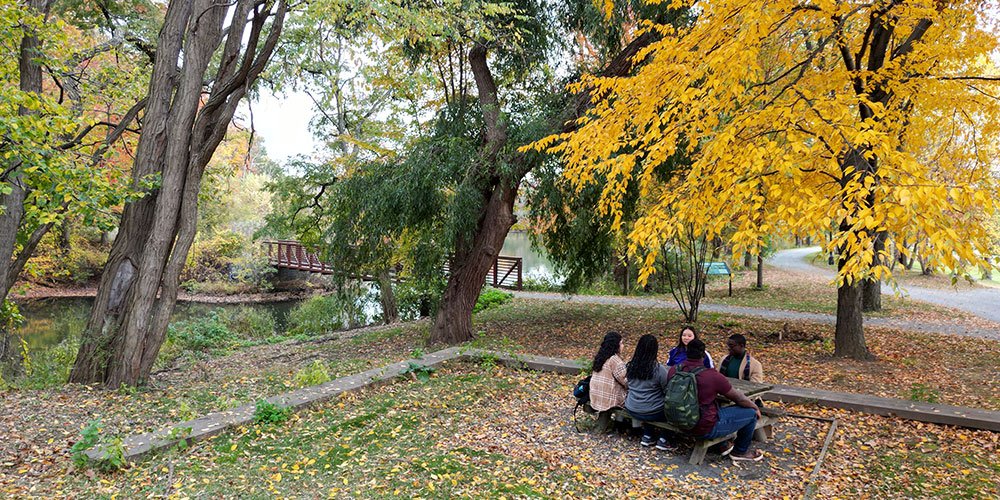 Students sitting at a table by Parker Pond