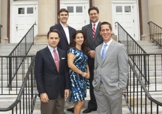 Five members of the PISCES team pose for a photo on a staircase in front of a building.