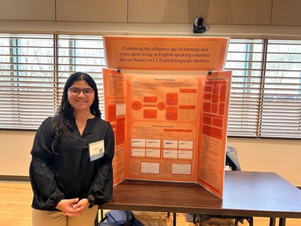Saumya Sawant stands beside her poster presentation in the Campus Center’s Multipurpose Room.