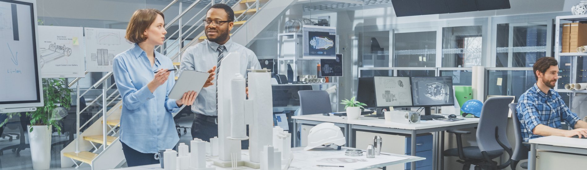 Two people in an office working on a city model.