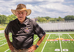 Coach Bob Ford poses in front of new field