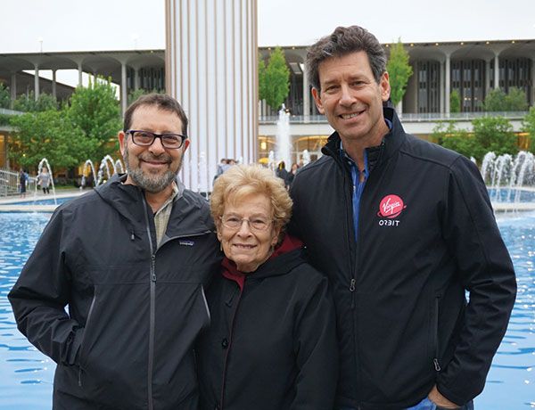 Dan Hart poses for a photo in front of the main fountain with his parents after speaking at commencement ceremony