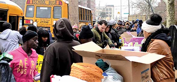 Claudio Gomez, in green jacket, and other UAlbany volunteers distribute necessities to Far Rockaway residents