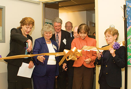 Attendees at the Emeritus Center dedication ceremony cut a large gold ribbon