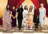 Several students standing and posing in traditional cultural clothing from various countries.