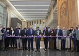 Ribbon cutting ceremony with group cutting purple ribbon