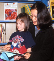 UAlbany student reading with elementary school student