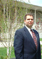 Peter Brusoe in front of the tree he planted on Campus Cleanup Day.