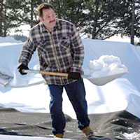 Tom Curtain shovels snow from the deflated Bubble.