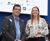Close-up photo of Amanda Dolan holding award at New York State Business Plan Competition. 