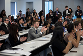 Students clap following a pitch in a School of Business classroom. 