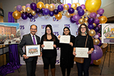 Photograph of President Rodríguez posing with three winners from the holiday card contest in front of banner.