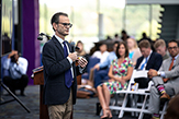 Sideview of Corrado speaking to crowd of faculty, staff, students and members of the local business community in the School of Business.