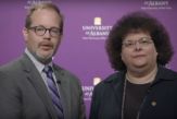 Jason Lane and Jeanette Altarriba in front of a purple UAlbany backdrop