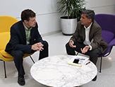 Bob Manasier speaks to a faculty member around a table in the lobby of University Hall 